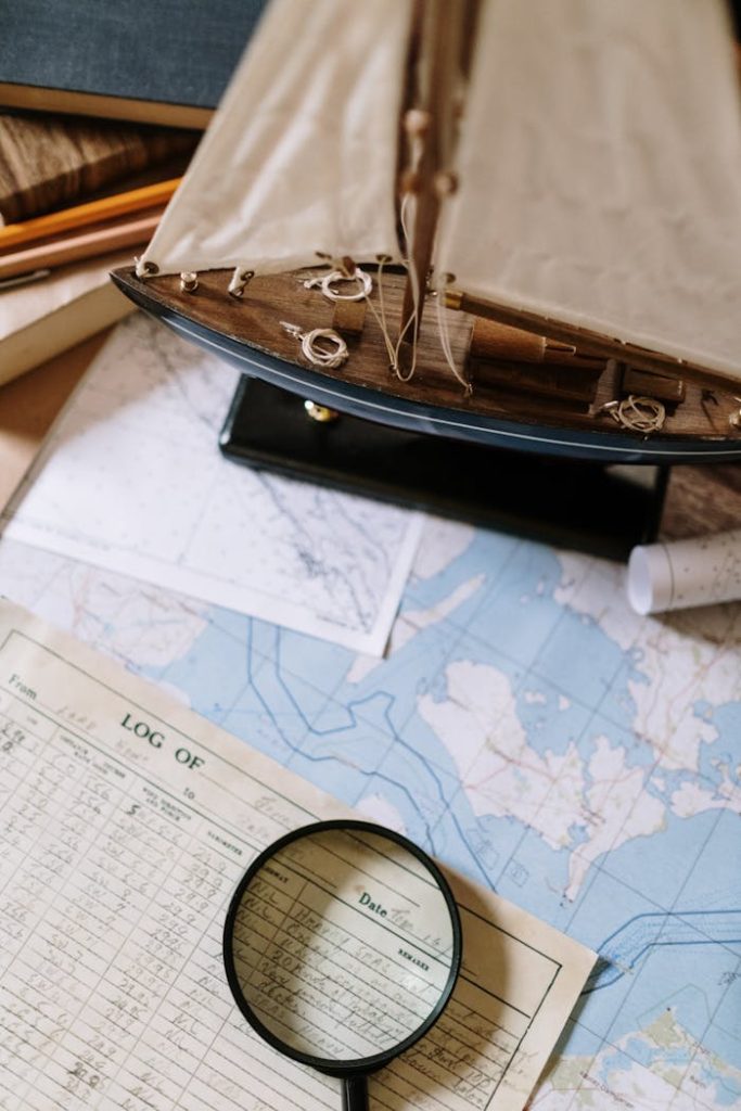 pexels photo 5370925 Close-up of nautical maps with a magnifying glass and model ship, ideal for maritime and exploration themes.