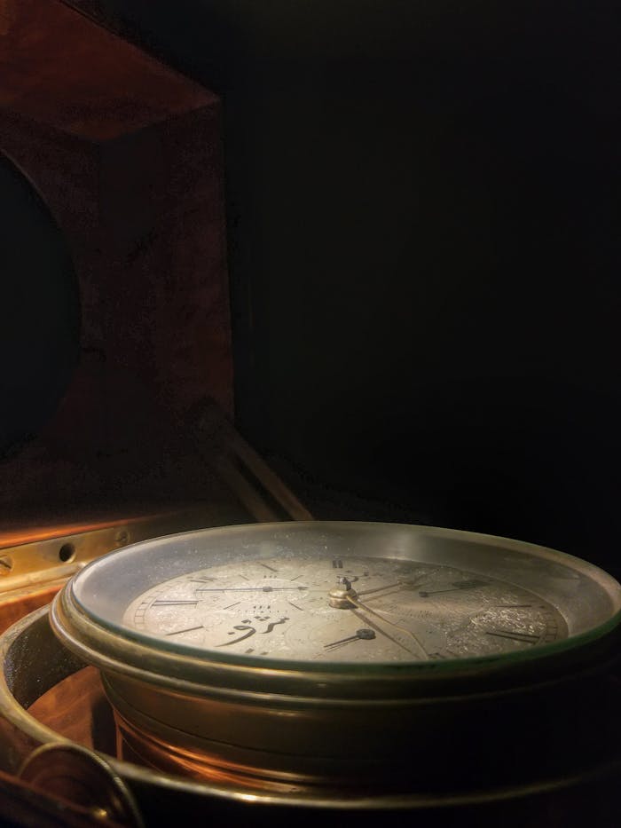 Discover the vintage allure of an antique nautical compass, set against a dark background.